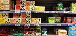 Rayonnage de supermarché avec trois rayons horizontaux comportant plusieurs séries de boîtes de thé.