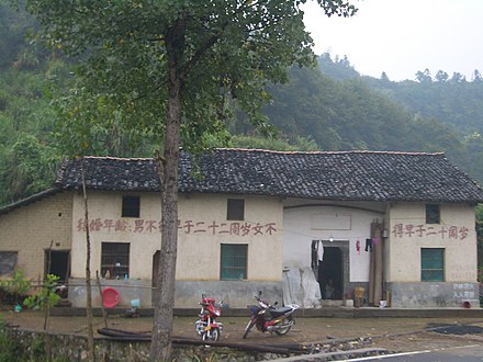 The sign painted on a building in a village in Hubei, China, informs of the marriageable age in the country (22 for men, 20 for women).