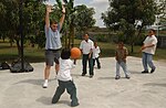 Miniatuur voor Bestand:US Navy 040219-M-7403H-007 U.S. Marine Sgt. Maj. Richard Dorsey, assigned to the “Ugly Angels” of Marine Heavy Helicopter Squadron Three Six Two (HMH-362) plays basketball with children.jpg