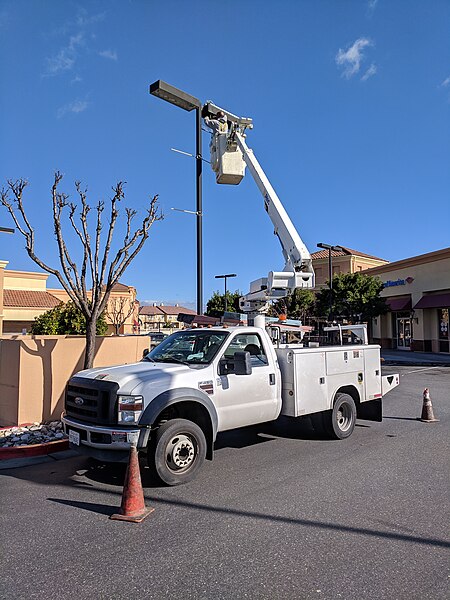 File:Worker servicing parking lot light from a cherry picker.jpg