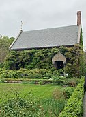 Stone building covered in green vines and other plants