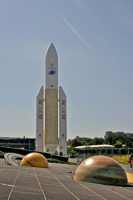 An Ariane 5 rocket, with models of Saturn and Jupiter in the foreground, at Cité de l'Espace in Toulouse.