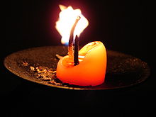 A candle auction closes when the flame of a wax candle runs out Candle stump on holder.jpg