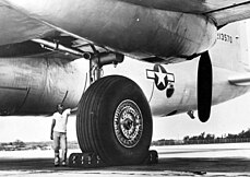 The single main tire of an XB-36 is about 1.5 times taller than the person standing beside it.