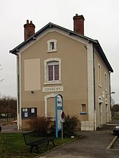 Photographie en couleurs d'une maison longée par une voie ferrée.