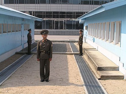 North Korean policemen standing guard at North Korea-South Korea border. View from North Korea.