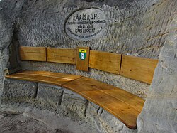 Dřevem pokrytá skalní tesaná lavice Karlova odpočinku