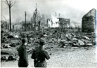 Солдаты войск СС на фоне горящей Нарвы в 1944 году. В дымке виден Нарвский Воскресенский собор