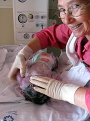 גיל הינקות מתחיל מרגע הלידה - תינוקת בת דקותיים עם המיילדת שיילדה אותה.