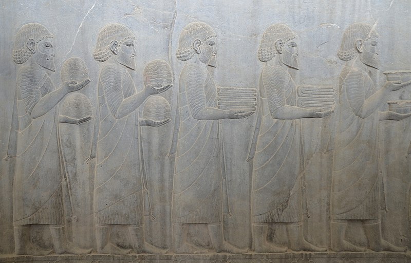 File:Relief on the southern wall of the east stairway of the Apadana depicting Ionian Greeks carrying what may be beehives and skeins of coloured wool, Persepolis, Iran (40897093913).jpg