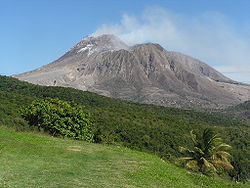 Large volcano rising above a tropical forest.