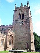 A stone Gothic tower with a clock face