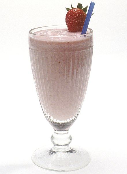 A strawberry milkshake topped with a strawberry