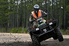 Ein geländegängiges Fahrzeug (ATV), das auf Schmutz fährt.