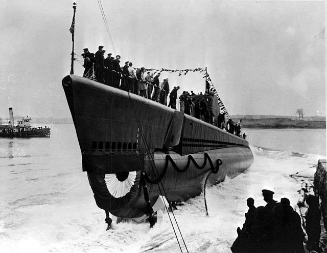 Sliding down the launching ways, Shad, backs into the waters of the Portsmouth Navy Yard.