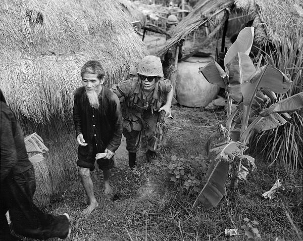 A U.S. Marine from 1st Battalion, 3d Marines, moves a supposed NLF activist to the rear during a search and clear operation held by the battalion 15 m