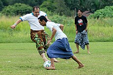 Villagers play football in traditional outfit Villagers play football in traditional dress (sarung).jpg