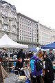 en: Flea market on the Naschmarkt, in the background Otto Wagner's buildings on the Linke Wienzeile can be seen de: Flohmarkt auf dem Naschmarkt, im Hintergrund die Otto-Wagner-Bauten an der Linken Wienzeile