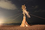 Large bonfire like structure on the beach.