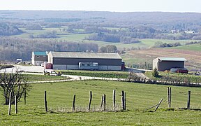 Galpões agrícolas modernos com vista para uma planície agrícola.