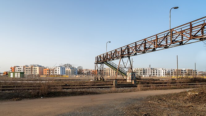 Old and new - abandoned pedestrian bridge across rail tracks in front of new development area in Brunswick/Germany.