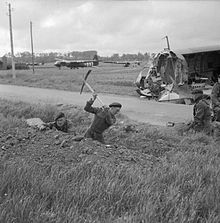 Britische Soldaten in der Normandie am zweiten Tag der Operation Overlord, 7. Juni 1944; im Hintergrund ein intakter, rechts ein zerstörter Horsa-Lastensegler