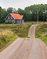 (~ 110 mm FF) A dip in the road in Färlev, Lysekil Municipality, Sweden, by W.carter. Telephoto compression makes the dip and the S curve much more interesting.