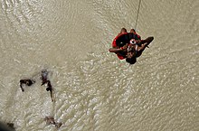 Una víctima de la inundación siendo rescatada por un helicóptero de la Fuerza Aérea India a la vista de las aldeas afectadas por la inundación donde el material de socorro fue arrojado por el helicóptero de la IAF en Bihar