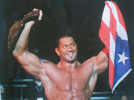 Batista holding the World Heavyweight Championship and a flag of Puerto Rico in 2006