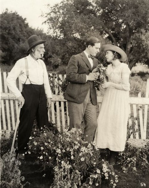 David Butler and Pitts look lovingly at each other while Jack McDonald glares in a scene still for the 1919 silent drama Better Times