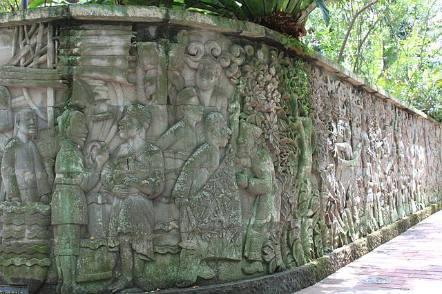 Carved mural on a wall in Fort Canning Park depicting activities which may have occurred in 14th-15th century Singapore.