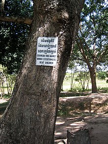 A Chankiri Tree. The sign reads "Chankiri Tree against which executioners beat children" ChoeungEk-Darter-7.jpg