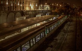 La stazione con un treno MF 77 al molo, di notte, vista verso Pointe du Lac.