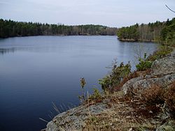 Grändalssjön-тің көл беті тасты және орманды жағалаулармен бейнеленген фотосуреті