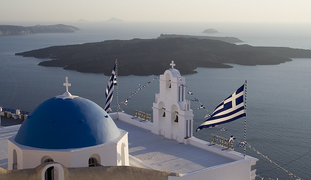 View of the Caldera of Santorini with a church in the foreground.