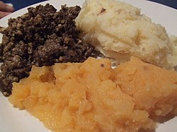 スコットランド料理 ハギス(左奥)。マッシュポテト (右奥)とカブのマッシュ (手前)