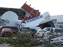 Photograph of a damaged building and storm debris
