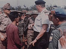 A POW is interviewed by a Canadian officer with the ICCS and a Provisional Revolutionary Government official in 1973. ICCS members interview repatriation refusal, Loc Ninh, 13 March 1973.jpg