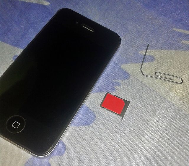 An iPhone 4 A1332 with a micro-SIM card removed with a paper clip, showing its SIM card compartment