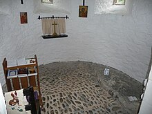 Interior of the apse, with the grave slab on the right Inside St. Melangell's church, Pennant Melangell - geograph.org.uk - 3107053.jpg