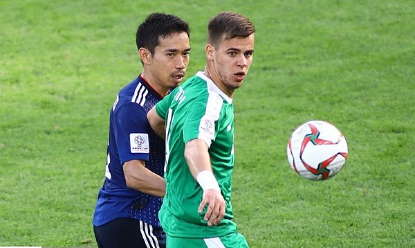 Japan's Yuto Nagatomo and Turkmenistan's Mihail Titow clash during the match