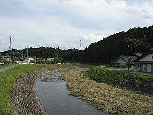 北側より川崎城を望む。城の東の天然の要害を成す宮川の右手手前の山が新城部。奥の中央向かってやや左寄りの山頂付近に主郭が存在する。