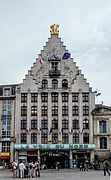 Foto do prédio do jornal La Voix du Nord, composto por quatro linhas de sete janelas no estilo neoflamand, com uma galeria comercial no térreo, telhado de duas águas com degraus de pardal e vista para as Três Graças.