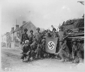 Lined up in front of a wrecked German tank and displaying a captured swastika, is a group of Yank infantrymen who were left behind to "mop-up" in Chambois, France, last stronghold of the Nazis in the Falaise Gap area. - NARA - 531503.gif