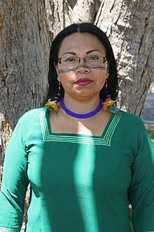 Medium close-up photograph of Mónica Chuji Gualinga dressing traditional clothes