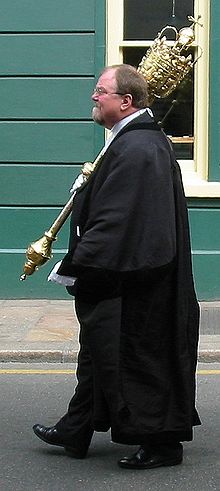 One of the functions of the Viscount in Jersey is to act as mace-bearer Mace bearer Liberation Day 2008 Jersey 2.jpg