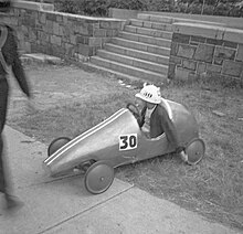 On Desjardins Avenue in 1967 is a racer awaiting a chance at victory Montreal Kinsmen Coaster Classic Soap Box Race Car.jpg