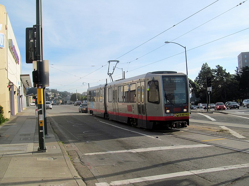 File:Northbound train at 19th Avenue and Junipero Serra, December 2017.JPG