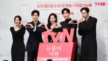 The series' main cast at a press conference doing hand hearts.