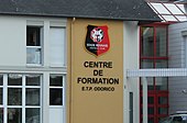 Fotografia do logótipo do Stade Rennes e da inscrição “Centro de formação ETP Odorico”.